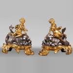 Pair of old gilded and silver bronze chenets decorated with putti straddling dolphins