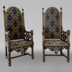 Pair of Neo-Gothic armchairs in walnut wood with sculpted face, late 19th century