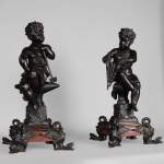 Pair of antique bronze and red andirons representing small blacksmiths