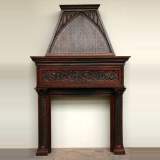 Oak mantel and hood with sculpted columns and holy leaves