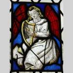 Two stained glasses elements with a harpist and a guitarist angels