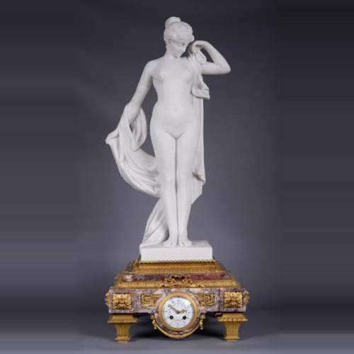 Peach blossom marble and gilt bronze clock surmounted by a statuary white marble   sculpture representing Phryne in front of his judges signed