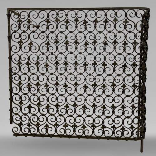 Wrought iron radiator railing decorated with volutes and fleur-de-lis