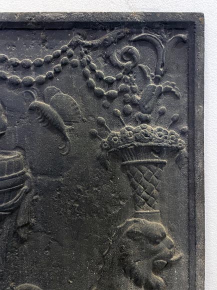 Fireback of the 18th century depicting a vase on a tripod with fire framed by two chimeras supporting baskets of fruit Fireback of the 18th century depicting a vase on a tripod with fire framed by two chimeras supporting baskets of fruit-2
