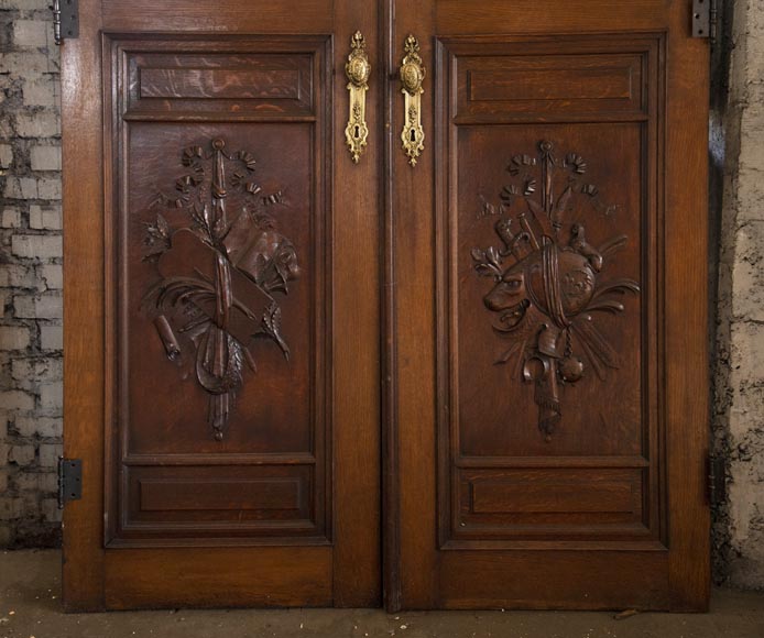 Double door in carved oak decorated with military trophies-4