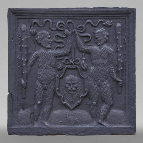 Antique fireback with two savages armed with masses