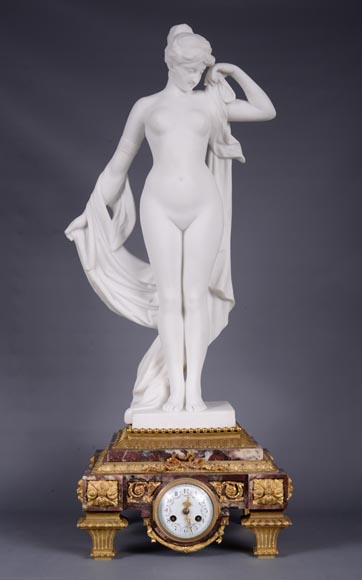 Peach blossom marble and gilt bronze clock surmounted by a statuary white marble   sculpture representing Phryne in front of his judges, signed 