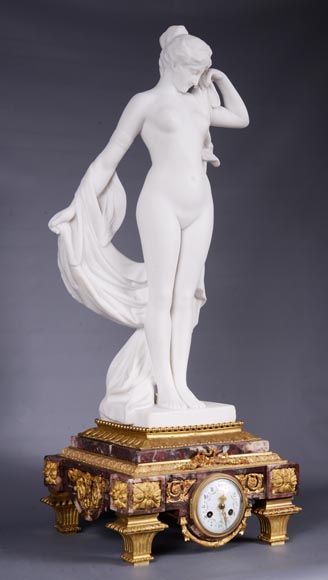 Peach blossom marble and gilt bronze clock surmounted by a statuary white marble   sculpture representing Phryne in front of his judges, signed 