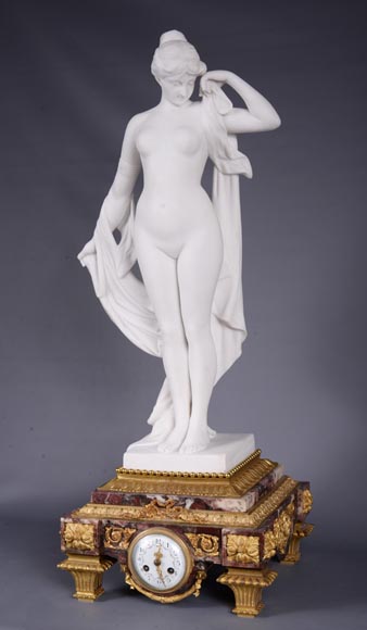 Peach blossom marble and gilt bronze clock surmounted by a statuary white marble   sculpture representing Phryne in front of his judges, signed 