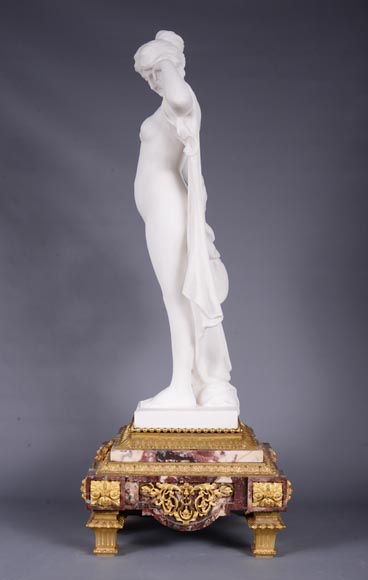 Peach blossom marble and gilt bronze clock surmounted by a statuary white marble   sculpture representing Phryne in front of his judges, signed 