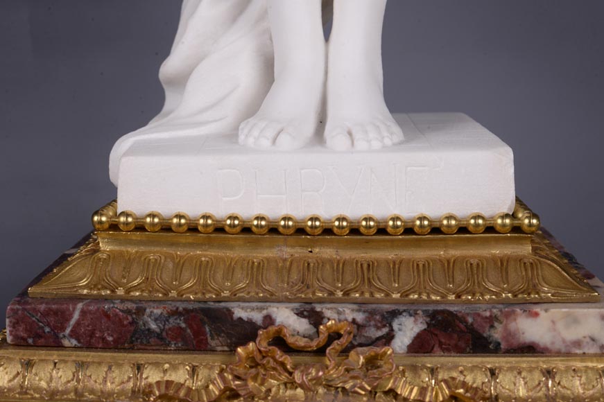 Peach blossom marble and gilt bronze clock surmounted by a statuary white marble   sculpture representing Phryne in front of his judges, signed 