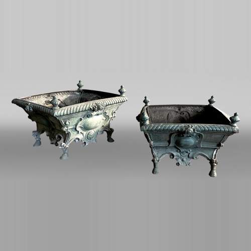 Pair of cast iron planters decorated with cartouches and lion heads