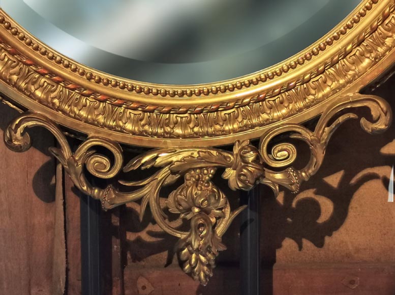 Louis XVI oval mirror in gilt wood with a vase and flowers