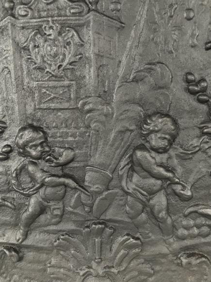 Cast iron fireback with putti firing a cannon-1