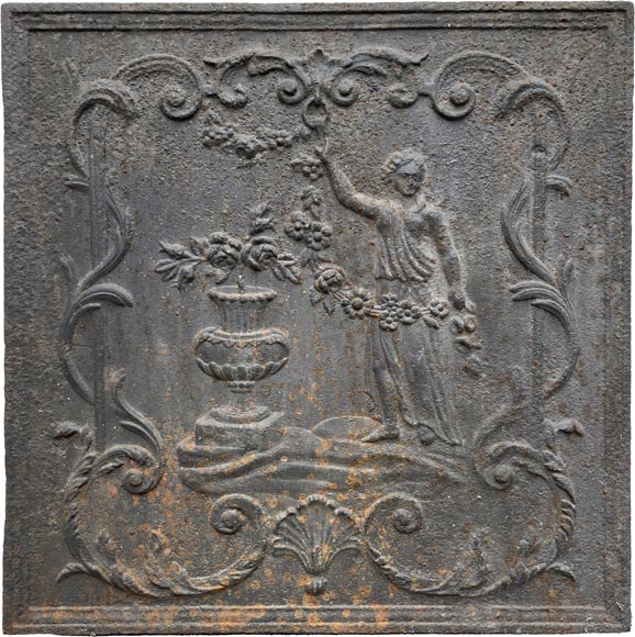 18th century fireback representing a female figure with a flower garland next to an antique vase-0