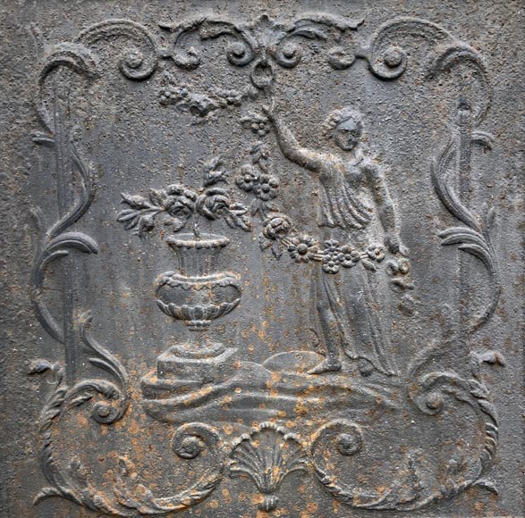 18th century fireback representing a female figure with a flower garland next to an antique vase-2