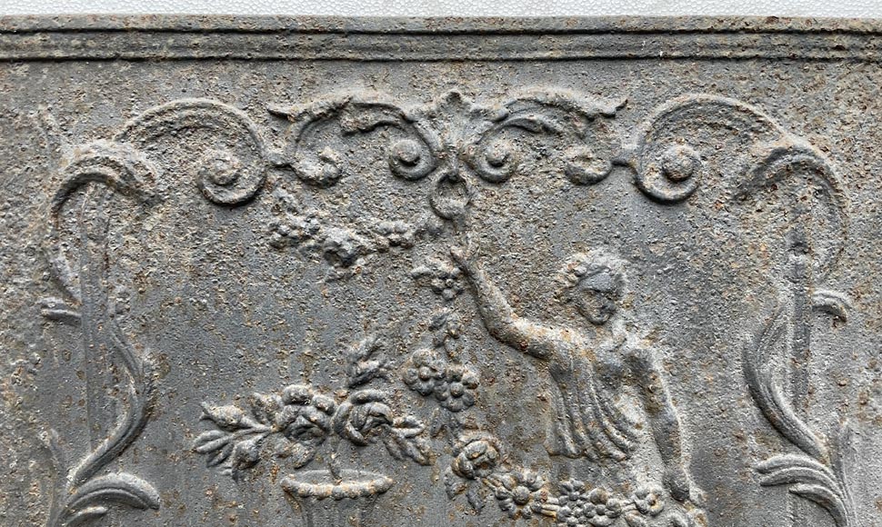 18th century fireback representing a female figure with a flower garland next to an antique vase-5