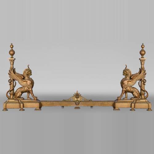 Pair of Egyptian-style gilt-bronze firedogs with confronting griffins