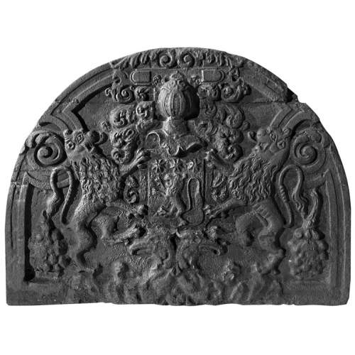 A semicircular cast iron fireplace plaque, decorated with a coat of arms, surmounted by a helmet and framed by lions.