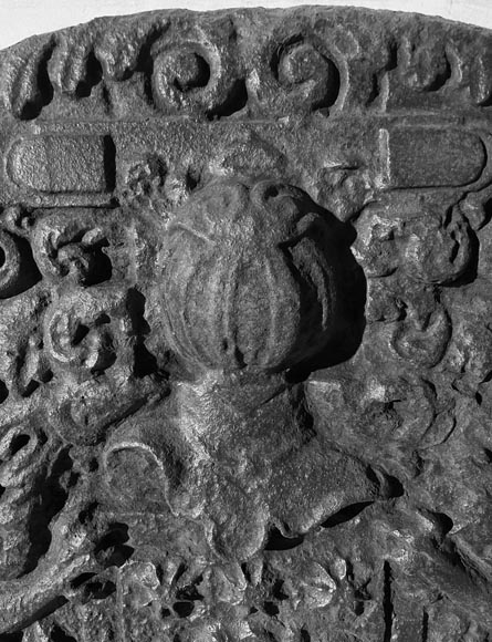 A semicircular cast iron fireplace plaque, decorated with a coat of arms, surmounted by a helmet and framed by lions.-3