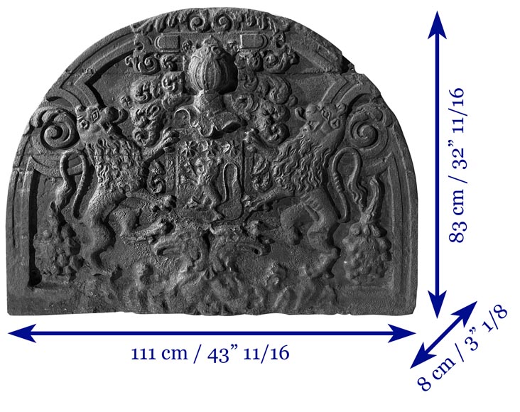A semicircular cast iron fireplace plaque, decorated with a coat of arms, surmounted by a helmet and framed by lions.-7