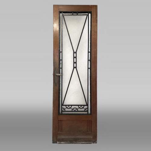 Art Deco interior door in wood and wrought metal, featuring geometric ornamentation and textured glass