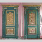 Pair of green doors with a gilded wooden decoration