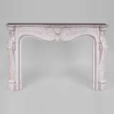 Beautiful antique Louis XV style fireplace with rich decor in white Carrara marble