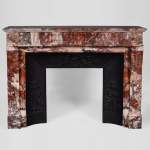 Beautiful antique Louis XVI style fireplace with flutings in Onyx rouge with its cast iron insert