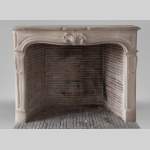 Beautiful antique Louis XV style fireplace in stone decorated with a palmette