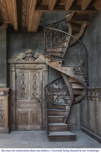 Beautiful spiral staircase with a wrought iron railing decorated with flowers and arabesques-0