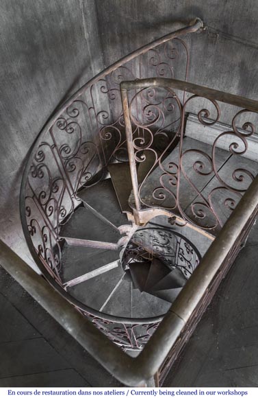 Beautiful spiral staircase with a wrought iron railing decorated with flowers and arabesques-3