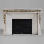 An antique Louis XVI style fireplace, made out of stone, with foliated decoration