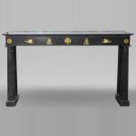 An antique Empire fireplace made out of black marble, witrh bronze ornaments and detached columns