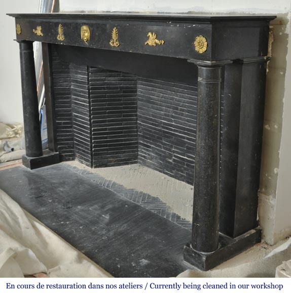 An antique Empire fireplace made out of black marble, witrh bronze ornaments and detached columns-7