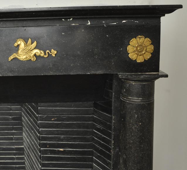 An antique Empire fireplace made out of black marble, witrh bronze ornaments and detached columns-8