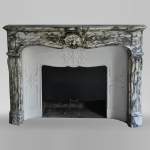 An antique Louis XV style fireplace made out of Brèche Violette marble
