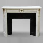 An antique Louis XVI style fireplace made out of Carrara marble with gilded bronze ornaments