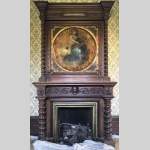 Antique walnut fireplace with trumeau decorated with a painting depicting the God Apollo