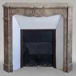An antique Louis XV style fireplace, Pompadour model, in Lunel marble
