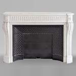 Large curved Louis XVI style fireplace with floral rudenture and acanthus leaf in Carrara marble