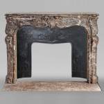 Louis XV period mantelpiece in Royal Red marble decorated with asymmetrical cartouches
