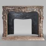 Louis XV period mantelpiece in Royal Red marble decorated with asymmetrical cartouches