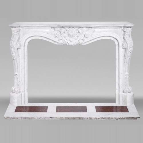 A highly sculpted Louis XV style fireplace in Carrara marble, decorated with a shell motif.