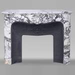 Regency style fireplace in purple breccia, decorated with a large shell