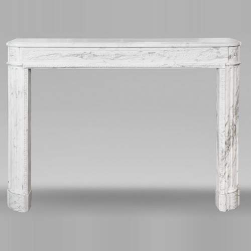 A Louis XVI period fireplace in veined Carrara marble, decorated with a Greek-style frieze.