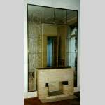 Mantel in travertine stone from the 1940's with surrounding wall of mirrors